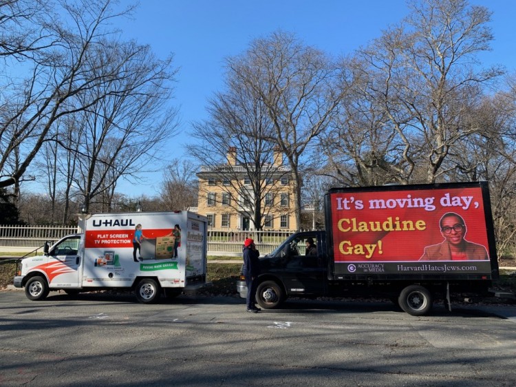 广告牌卡车停在前哈佛校长官邸外上面写着今天是搬家日克劳丁盖伊
